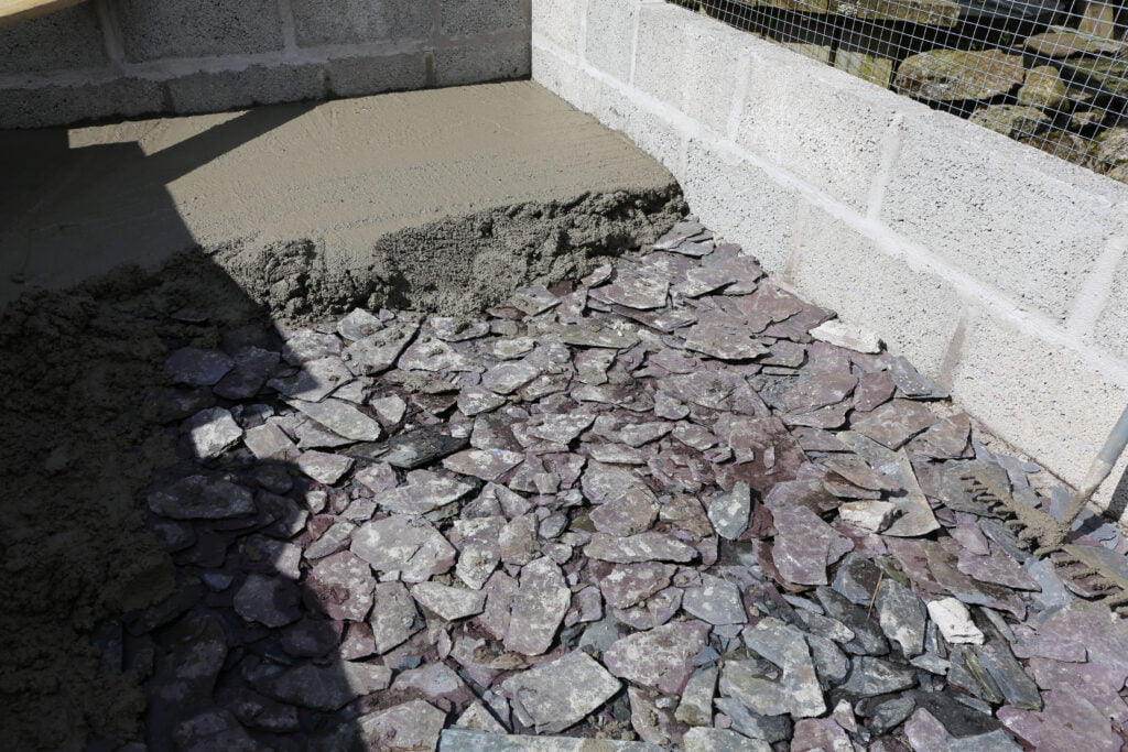 Pouring the concrete floor on a slate DPC